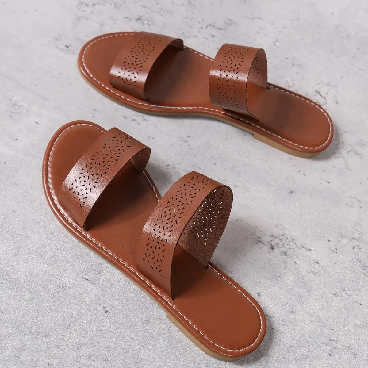 brown women's flat slide sandals showing the perforated strap pattern