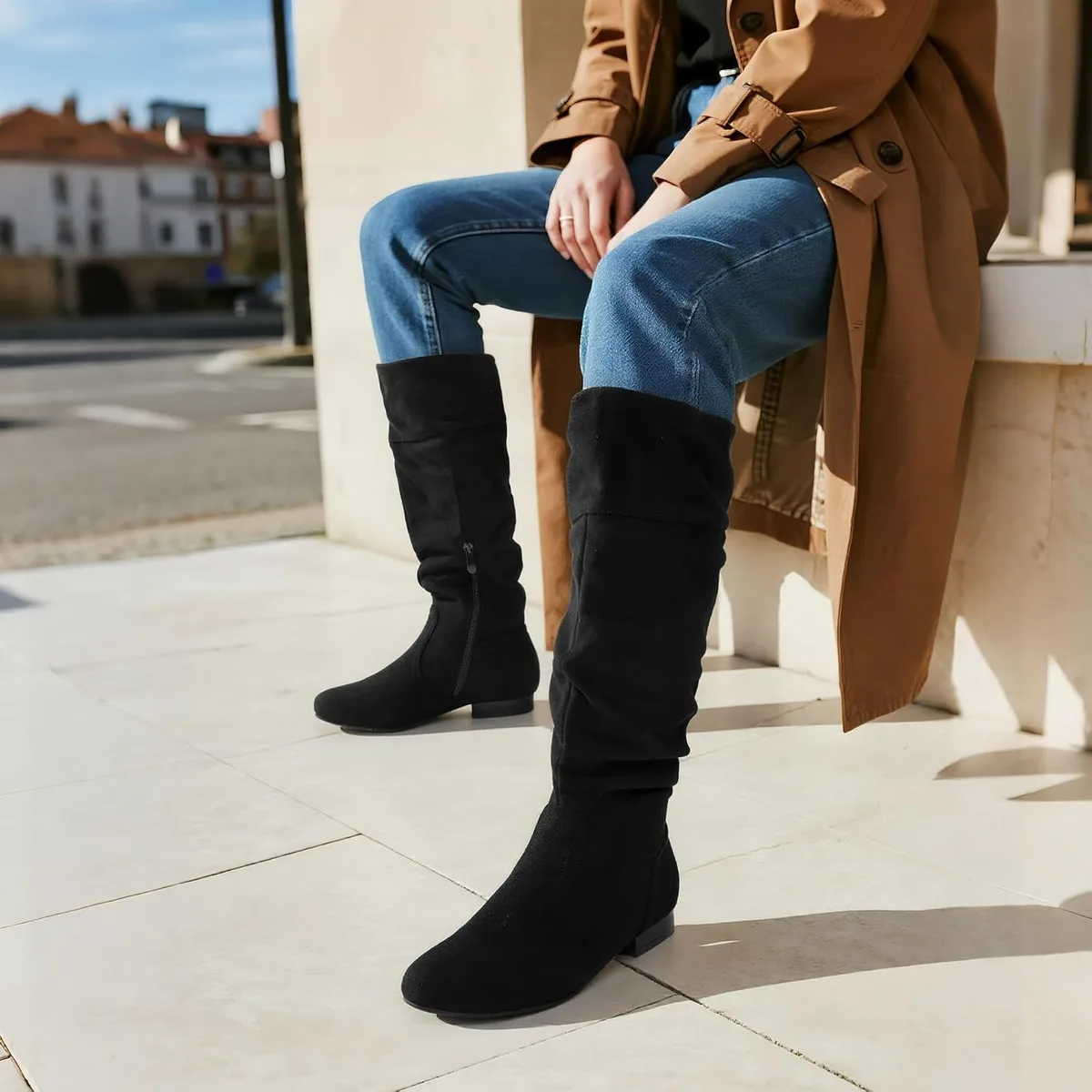 black slouchy knee high boots worn over blue jeans