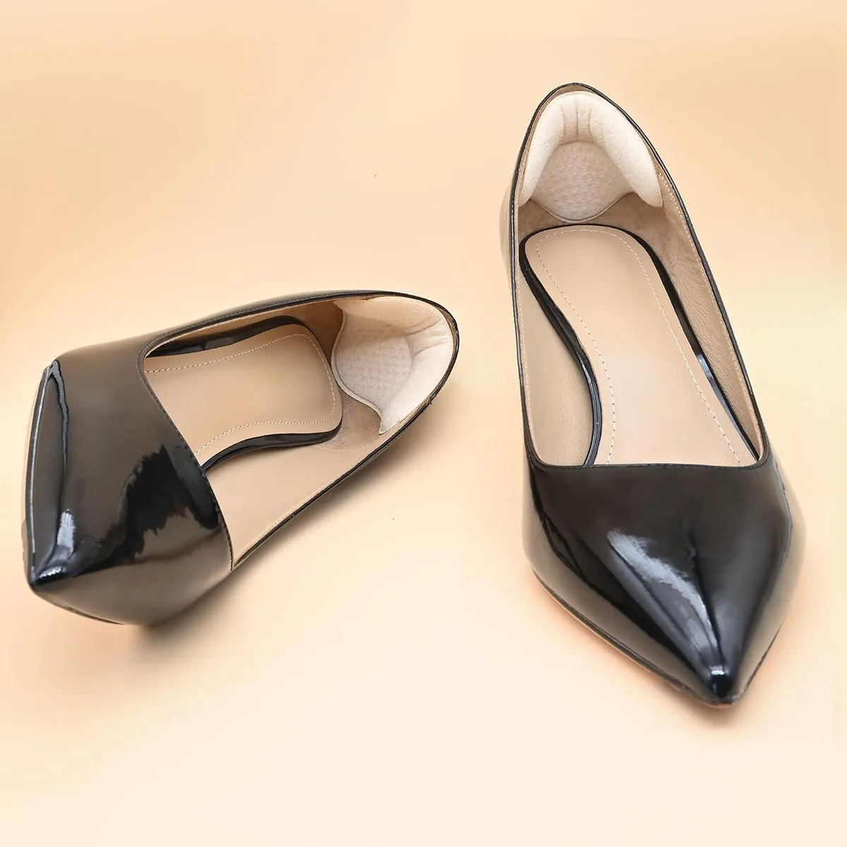 beige heel cushion pads fitted inside black patent pumps