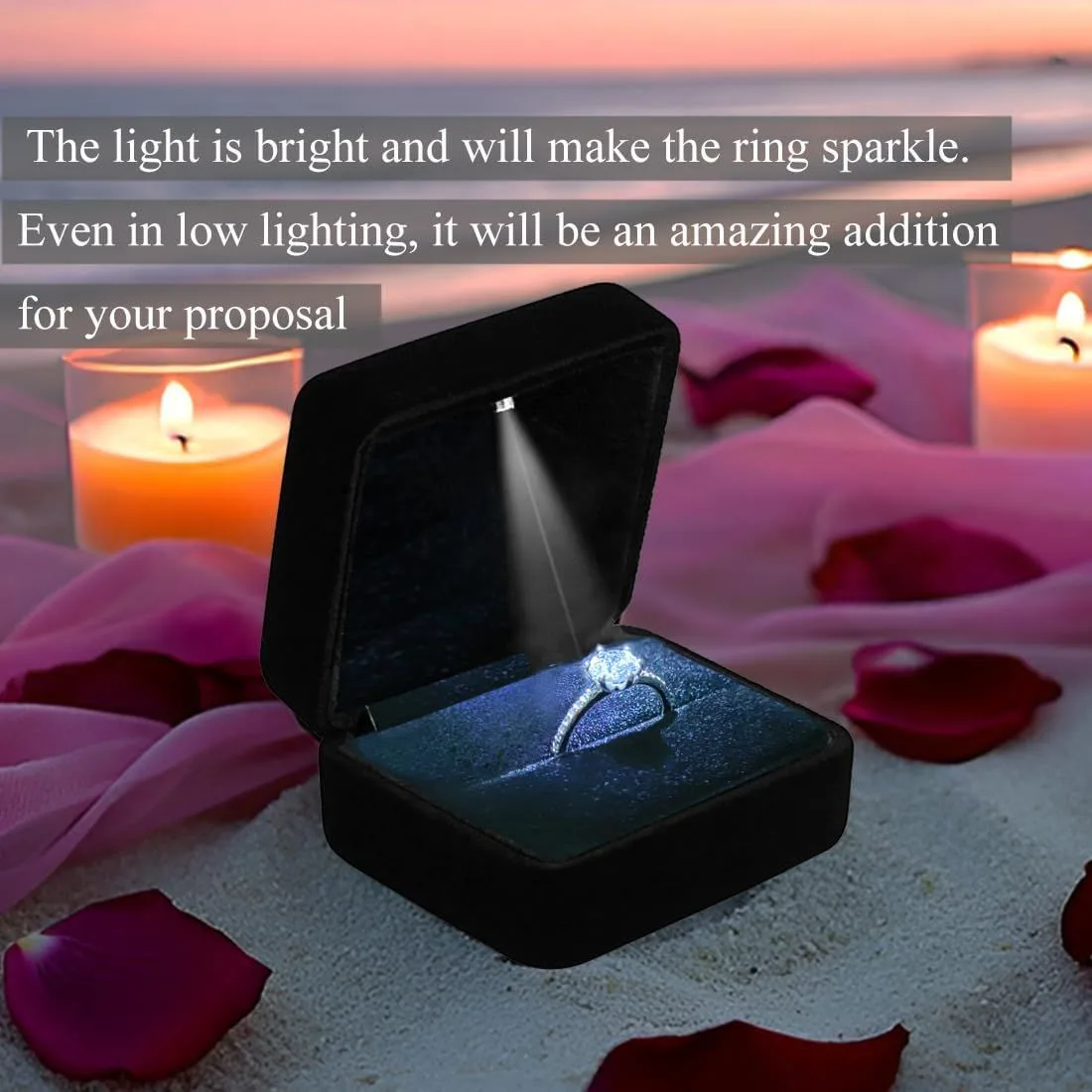 velvet LED ring box lighting up a diamond ring on a candlelit beach