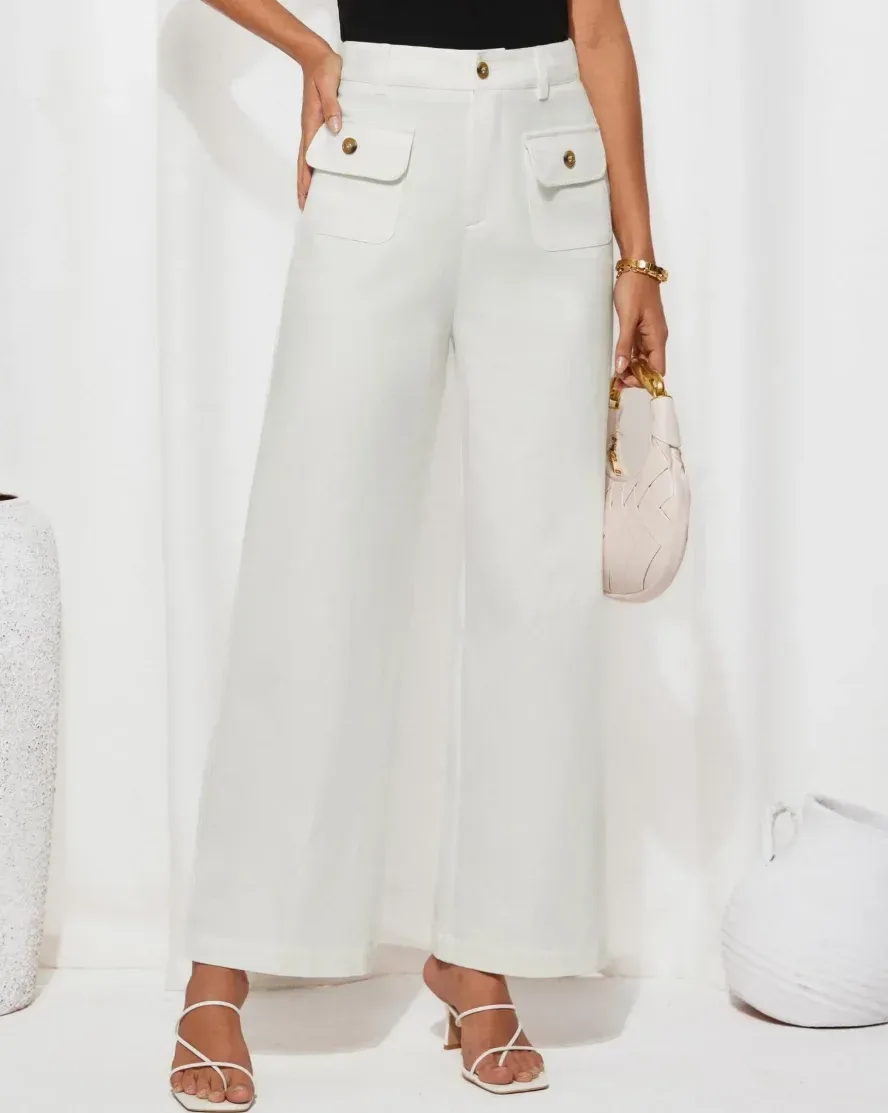 high waisted work pants worn with a black top and a small bag