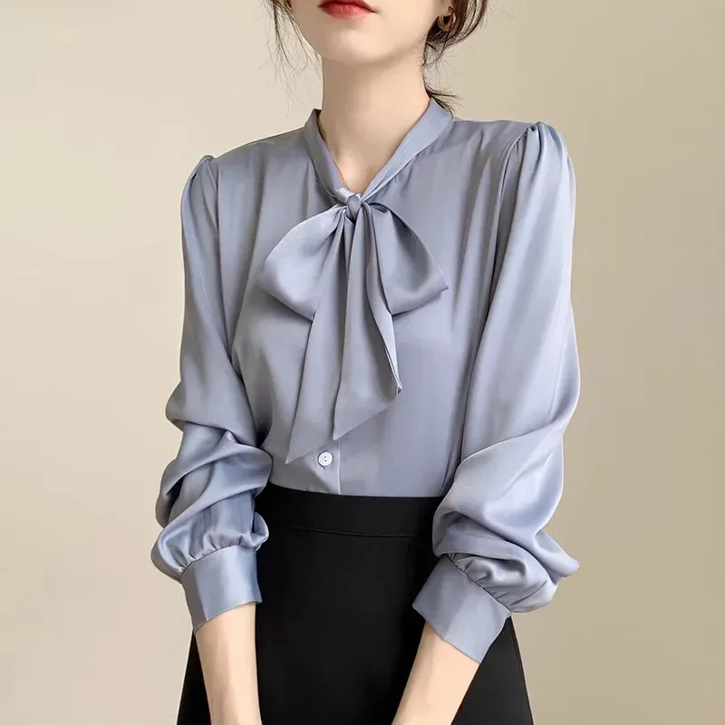 satin tie neck bow blouse tucked into a skirt for a polished look