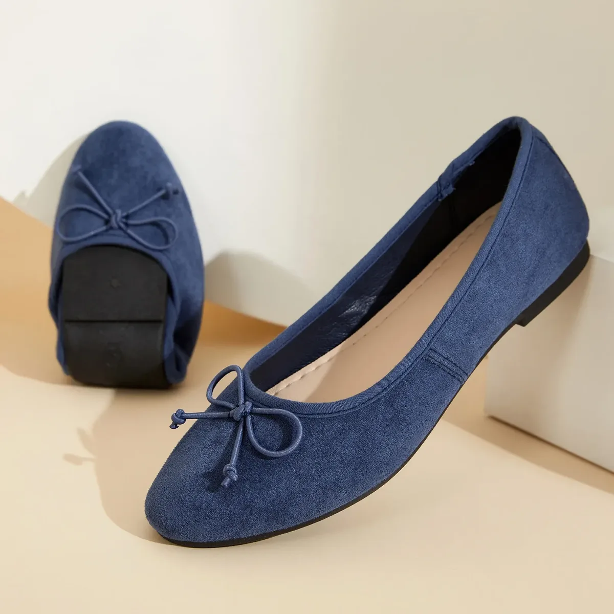 navy microsuede ballet flat showing the rubber outsole and gathered collar