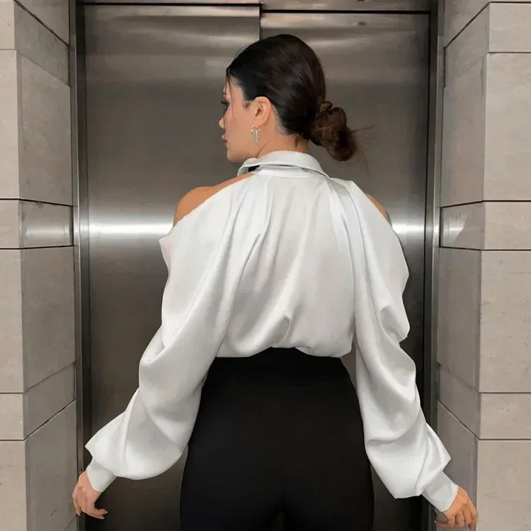 back view of the white satin cold shoulder shirt tucked into trousers