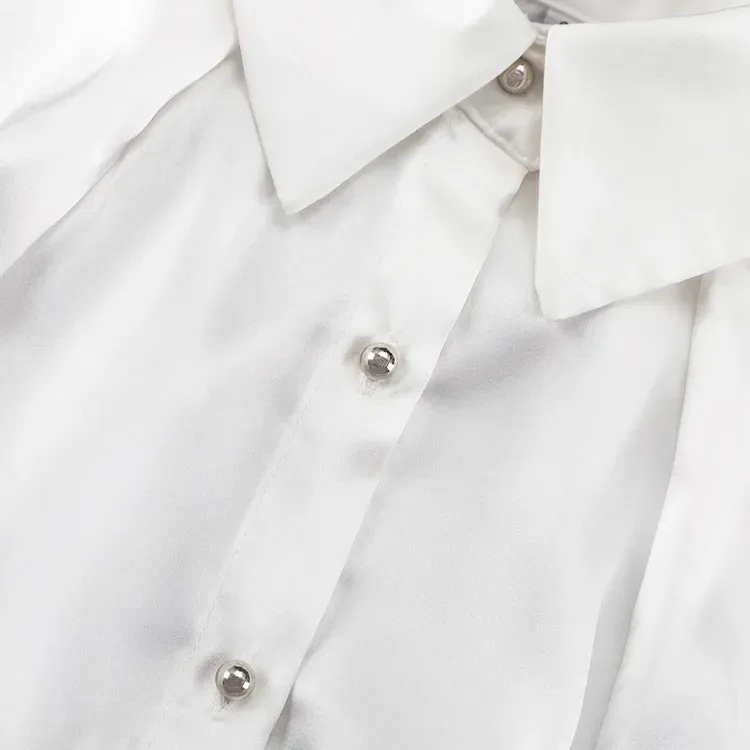 pointed collar and silver buttons on the white satin shirt