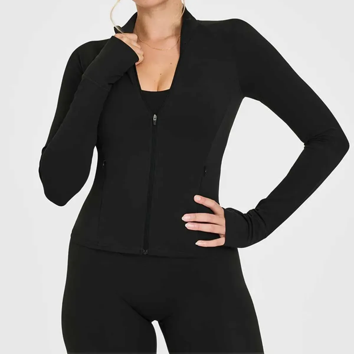 black fitted zip jacket from the activewear set worn over a sports bra