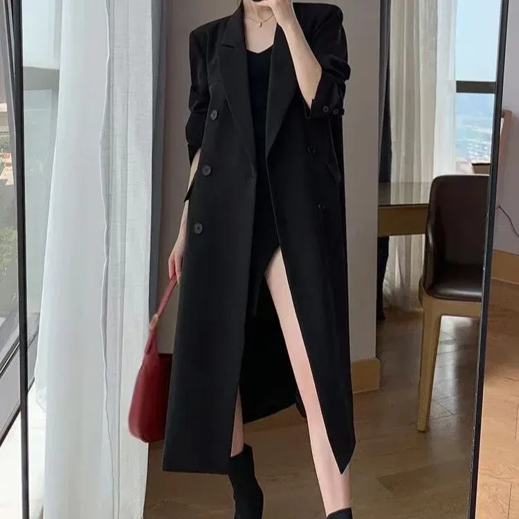 black long double breasted coat styled over a mini dress
