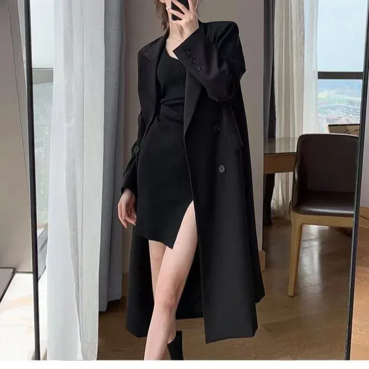 relaxed fit of the black long double breasted coat worn open