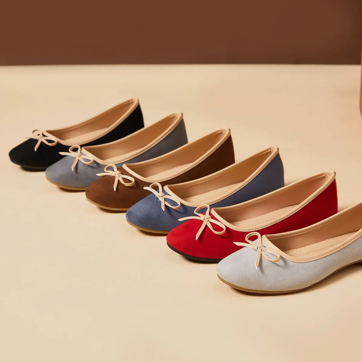 row of women's bow ballet flats in black, gray, brown, blue, red and light gray