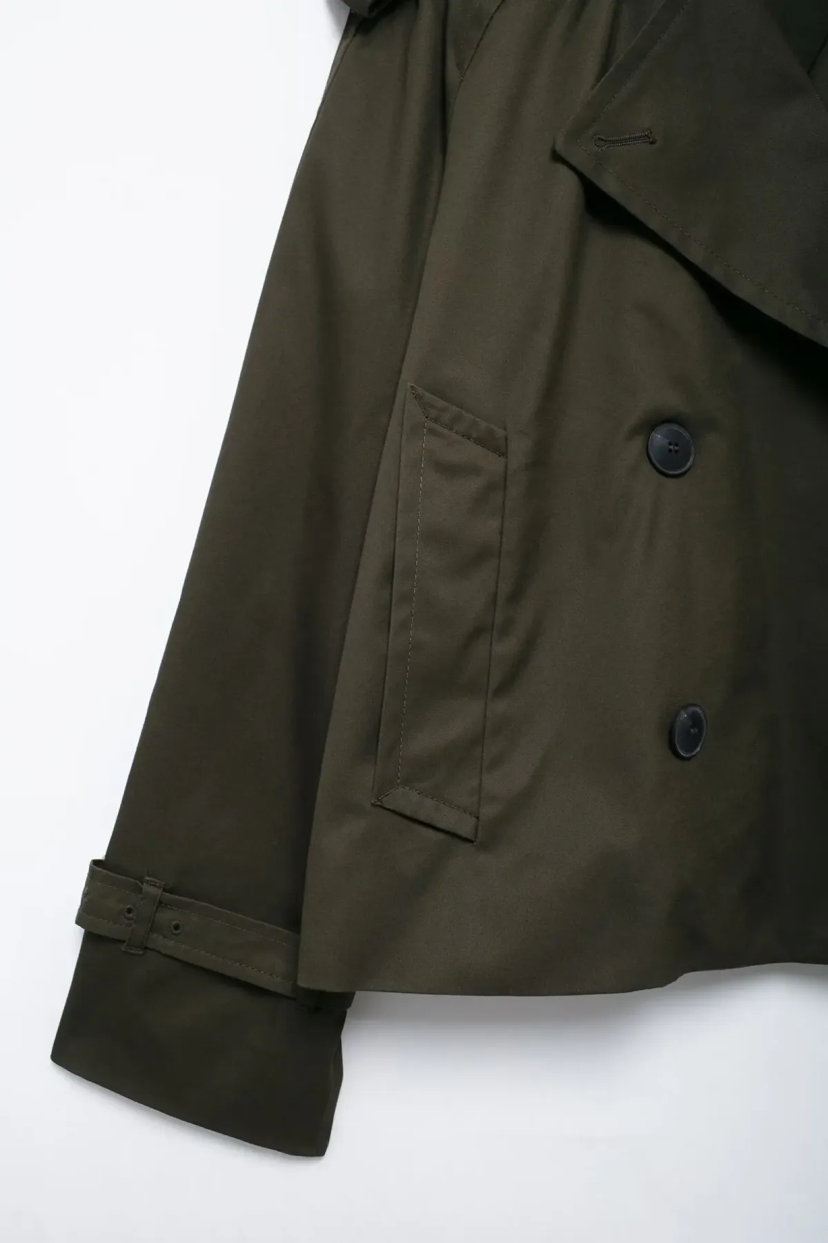 cuff strap and front pocket of the cropped trench jacket