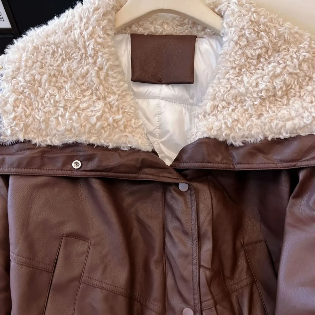 close up of the curly faux fur collar on the coffee jacket