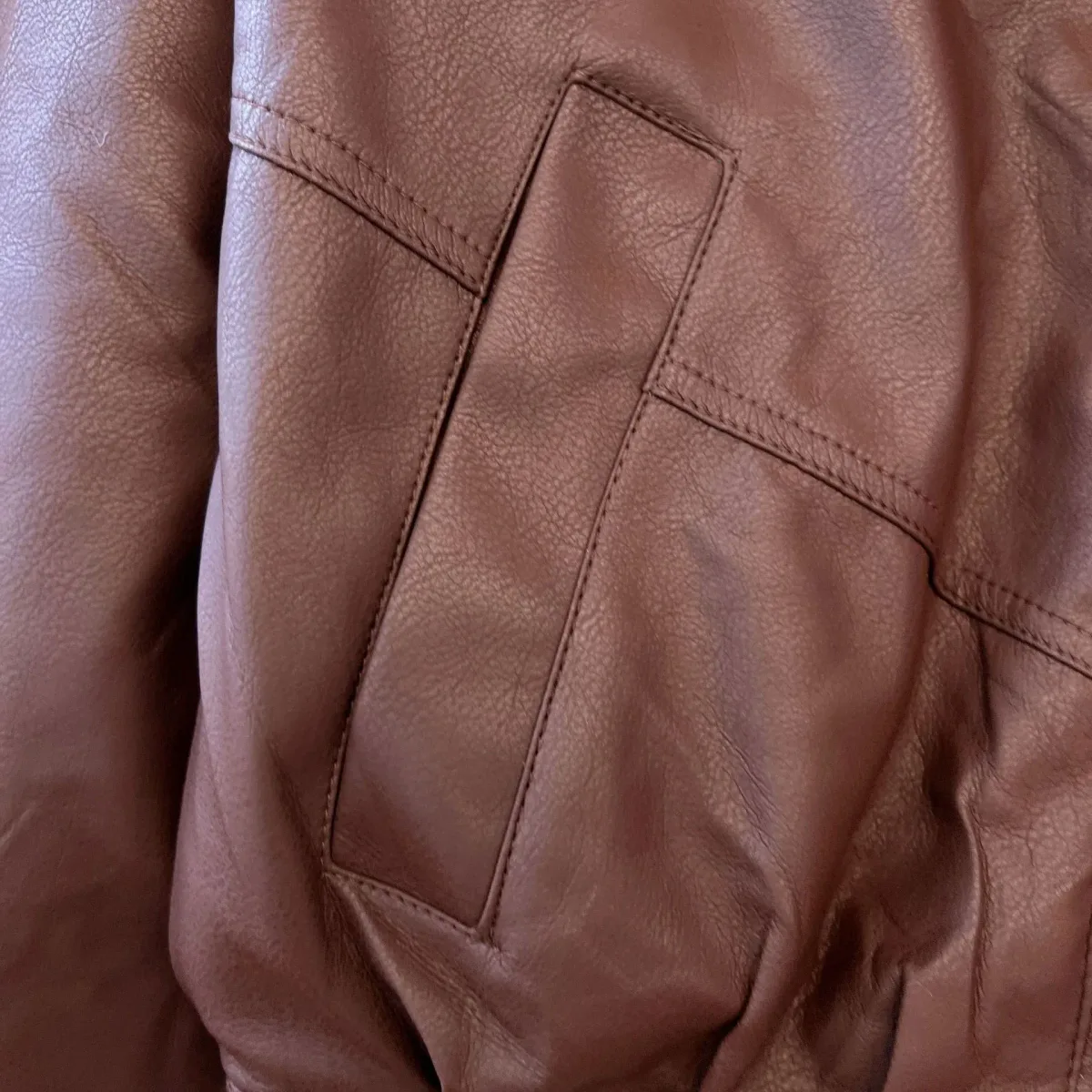 front pocket detail of the coffee faux leather jacket