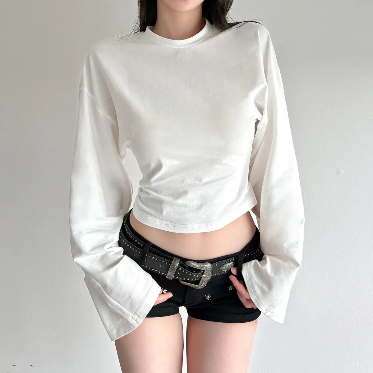 cropped length of the white bell sleeve knit top